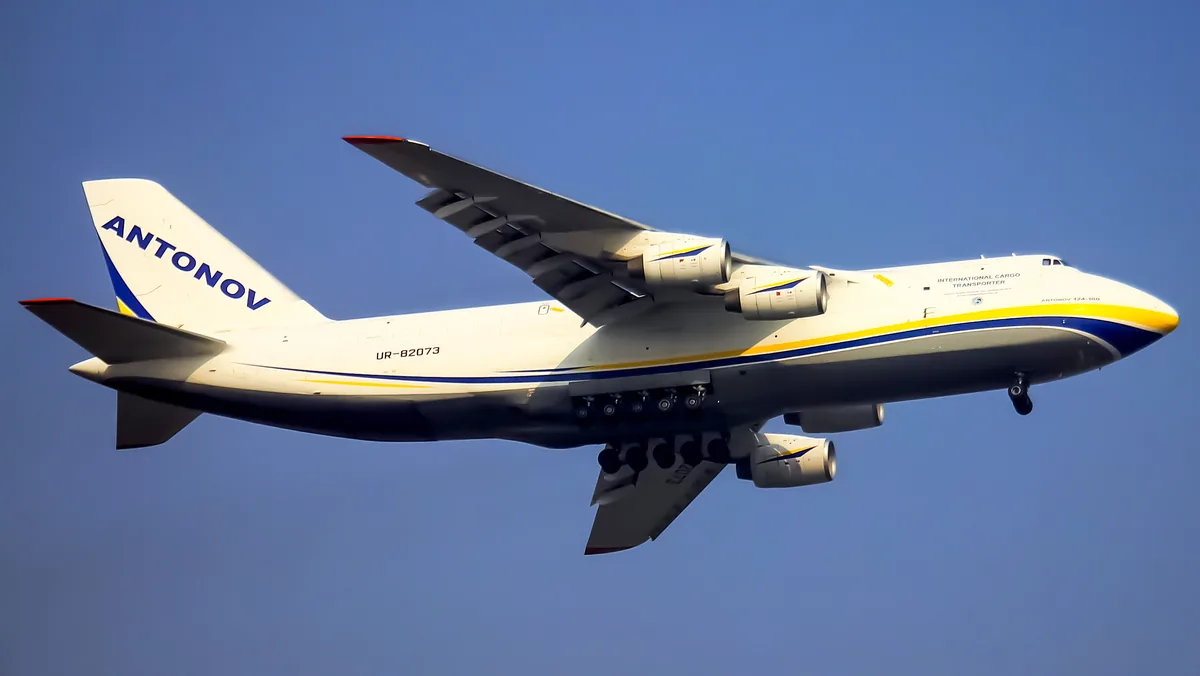 Representative Antonov An-124-100 cargo aircraft in flight with its landing gear extended.