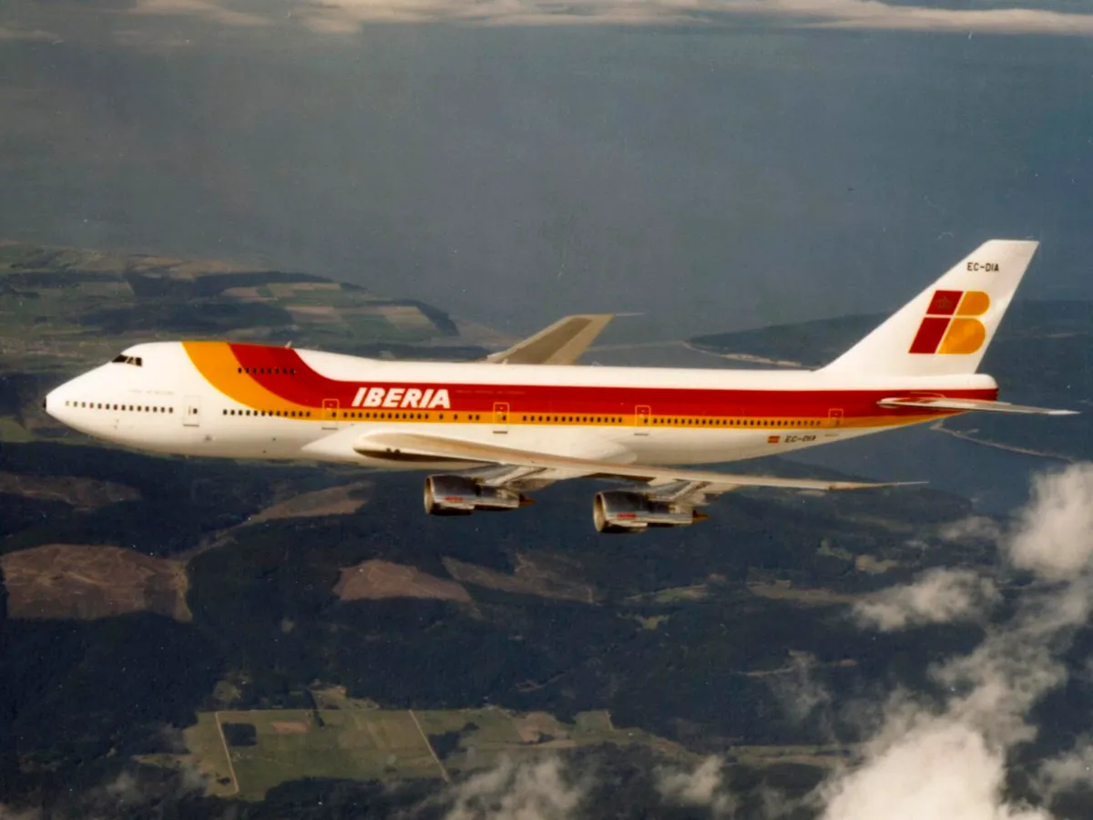 Representative Boeing 747-200 in Iberia colors in flight above clouds.