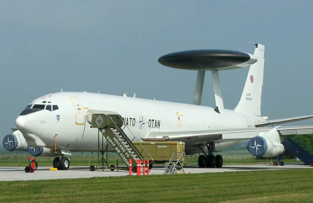 Representative Boeing E-3 Sentry with its rotating radar dome, parked with boarding stairs.
