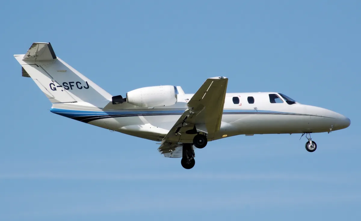 Representative Cessna 525 CitationJet on approach with its landing gear down.