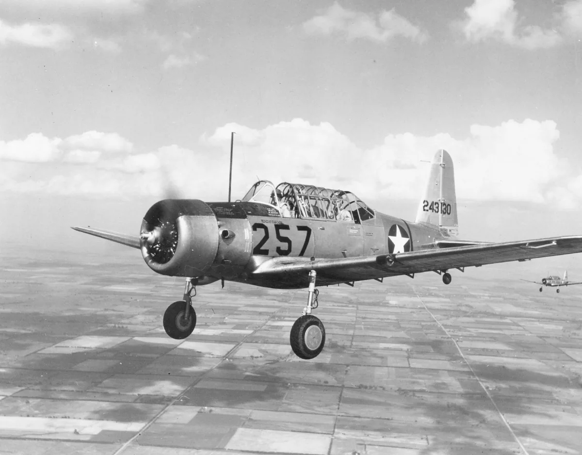 Historical black-and-white photograph of a Vultee BT-13A Valiant in flight, representative of the VALI aircraft family.